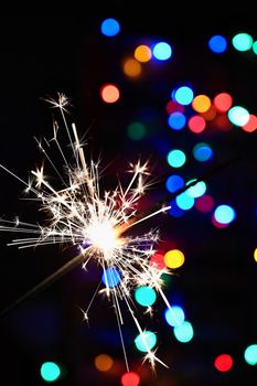 Concept for Christmas and Happy New Year.
Burning sparkler with beautiful color background.
