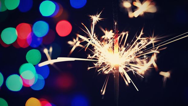 Concept for Christmas and Happy New Year.
Burning sparkler with beautiful color background.
