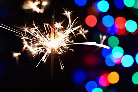Concept for Christmas and Happy New Year.
Burning sparkler with beautiful color background.
