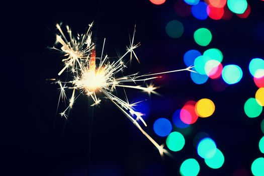 Concept for Christmas and Happy New Year.
Burning sparkler with beautiful color background.
