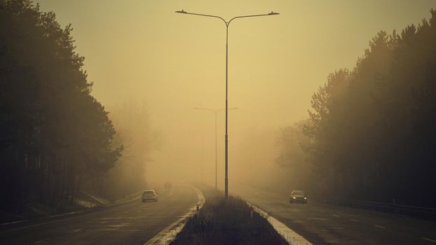 Cars in the fog. Bad winter weather and dangerous automobile traffic on the road. Vehicles in fog.