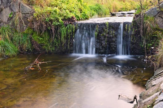 A beautiful clean brook in the countryside with a sink and running water.