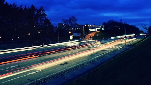 Night photo traffic on the road. Evening landscape with cars. Cars with lights and blurred color lines.