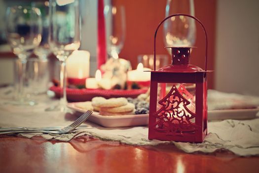 Beautifully set table for Christmas holidays. Candies, candles and Christmas decorations - decorated home on Christmas Eve.