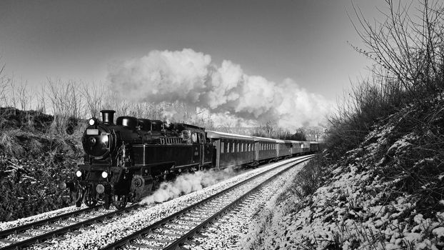 Beautiful old steam train with wagons running on rails at sunset. Excursions for children and parents on festive special days. Czech Republic Europe.