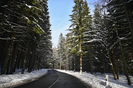 Road in winter. Snowy mountain path for a car. Concept for traveling and safe driving in winter by car.