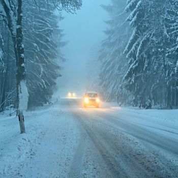 Snowy winter road with car. Dangerous car driving in the mountains in the winter. Concept for transportation, cars and travel.