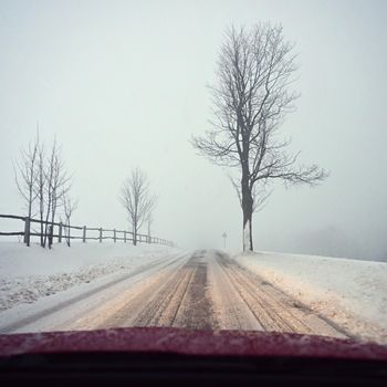 Driving the car in the winter. View from the interior of a car on a snowy road by the eyes of the driver. Concept for driving safety in the winter.