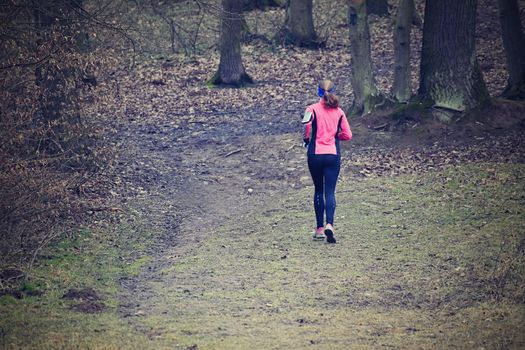 Running woman in nature in forest