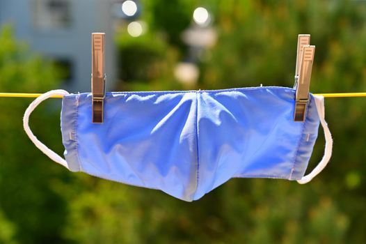 Face mask- respirator on a clothesline. Washing and disinfection against coronavirus COVID - 19.