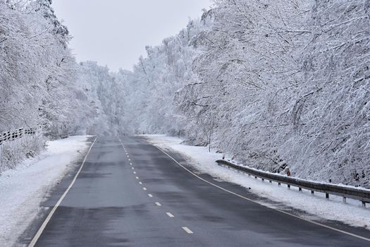 Road in winter. Snowy mountain path for a car. Concept for traveling and safe driving in winter by car.