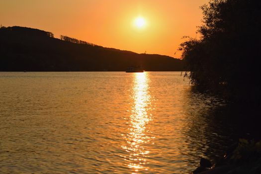 Brněnská přehrada, the city of Brno-Europe. Beautiful sunset by water with a boat.