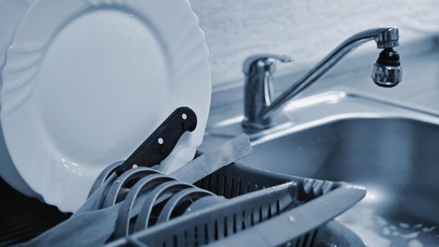 Dishes in drip tray. Clean washed dishes in the kitchen.