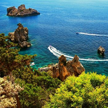 Beautiful beach and boats. Clean sea with a bay. Concept for travel, vacation and tourism. Great place for summer holidays and swimming. Paleokastritsa, Corfu island, Greece.
