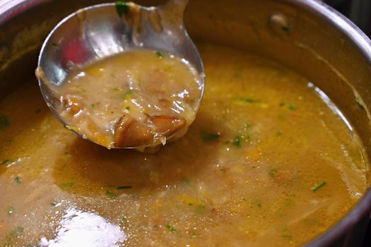 Taking soup into a plate. Delicious homemade mushroom soup served in a plate.