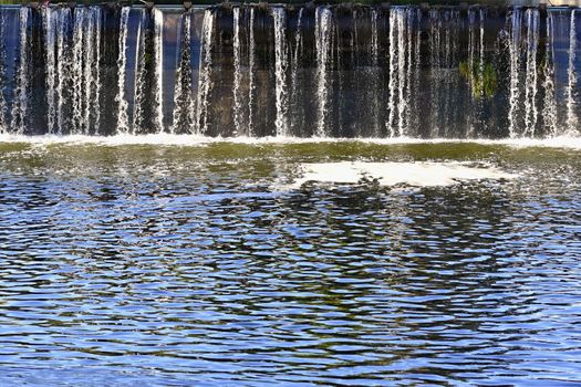 Sluice on the river. Flowing clean water in the river