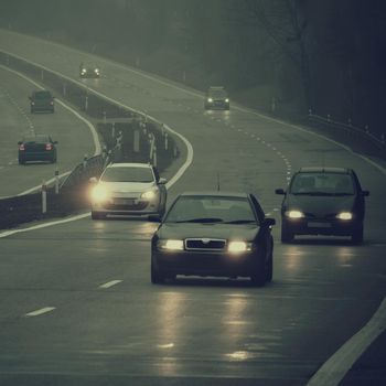 Bad weather driving - foggy hazy country road. Motorway - road traffic. Winter time.