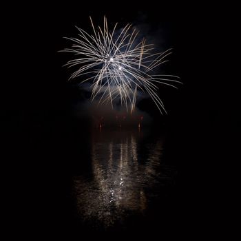 Beautiful colorful fireworks on the water surface with a clean black background. Fun festival and international contest of Firefighters from all over the world Ignis Brunensis 2017. Brno Dam - Czech Republic.