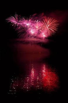 Beautiful colorful fireworks on the water surface with a clean black background. Fun festival and international contest of Firefighters from all over the world Ignis Brunensis 2017. Brno Dam - Czech Republic.