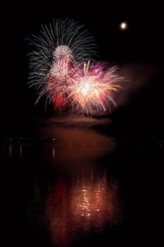 Beautiful colorful fireworks on the water surface with a clean black background. Fun festival and international contest of Firefighters from all over the world Ignis Brunensis 2017. Brno Dam - Czech Republic.