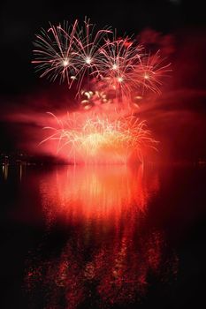 Beautiful colorful fireworks on the water surface with a clean black background. Fun festival and international contest of Firefighters from all over the world Ignis Brunensis 2017. Brno Dam - Czech Republic.