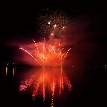 Beautiful colorful fireworks on the water surface with a clean black background. Fun festival and international contest of Firefighters from all over the world Ignis Brunensis 2017. Brno Dam - Czech Republic.