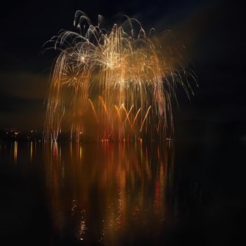 Beautiful colorful fireworks on the water surface with a clean black background. Fun festival and international contest of Firefighters from all over the world Ignis Brunensis 2017. Brno Dam - Czech Republic.