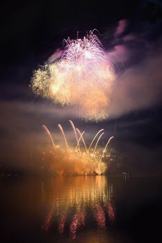 Beautiful colorful fireworks on the water surface with a clean black background. Fun festival and international contest of Firefighters from all over the world Ignis Brunensis 2017. Brno Dam - Czech Republic.