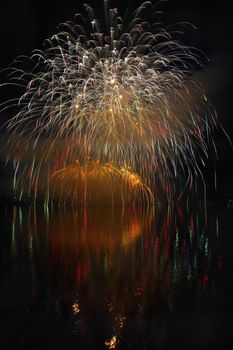 Beautiful colorful fireworks on the water surface with a clean black background. Fun festival and international contest of Firefighters from all over the world Ignis Brunensis 2017. Brno Dam - Czech Republic.