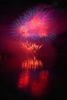 Beautiful colorful fireworks on the water surface with a clean black background. Fun festival and international contest of Firefighters from all over the world Ignis Brunensis 2017. Brno Dam - Czech Republic.