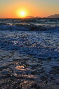 Beautiful sunset with sea and waves. Natural colorful background. Concept for summer and sea vacation. Greece - island of Kos.