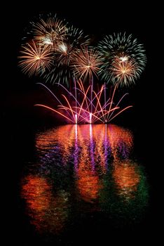 Firework. Beautiful colorful fireworks on the water surface with a clean black background. Fun festival and contest of Firefighters  Brno Dam - Czech Republic.