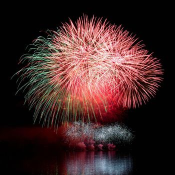 Firework. Beautiful colorful fireworks on the water surface with a clean black background. Fun festival and contest of Firefighters  Brno Dam - Czech Republic.