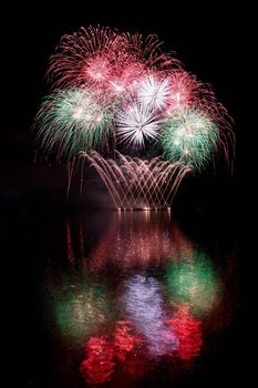 Firework. Beautiful colorful fireworks on the water surface with a clean black background. Fun festival and contest of Firefighters  Brno Dam - Czech Republic.