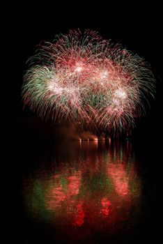 Firework. Beautiful colorful fireworks on the water surface with a clean black background. Fun festival and contest of Firefighters  Brno Dam - Czech Republic.