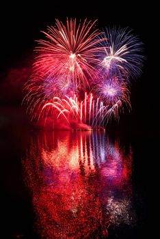 Firework. Beautiful colorful fireworks on the water surface with a clean black background. Fun festival and contest of Firefighters  Brno Dam - Czech Republic.