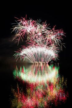 Firework. Beautiful colorful fireworks on the water surface with a clean black background. Fun festival and contest of Firefighters  Brno Dam - Czech Republic.