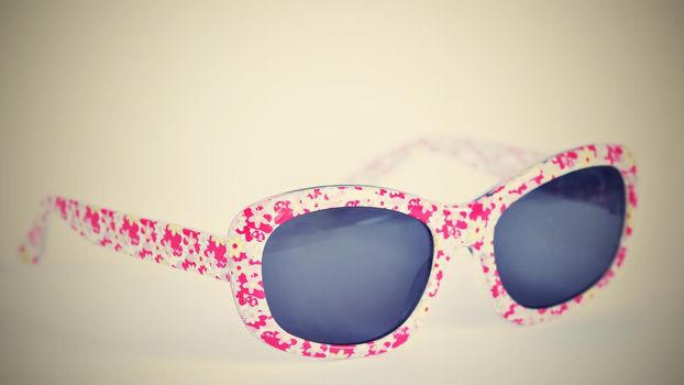 Sunglasses. Baby, pink-white colorful glasses isolated on a clean white background.