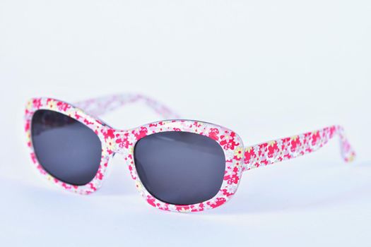 Sunglasses. Baby, pink-white colorful glasses isolated on a clean white background.