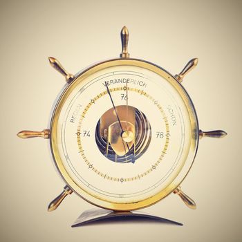 Beautiful old barometer. The shape of the rudder. Isolated on a clean white background