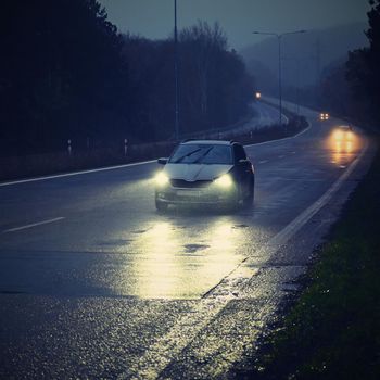 Car on the road in the fog. Autumn landscape - dangerous road traffic in winter season.