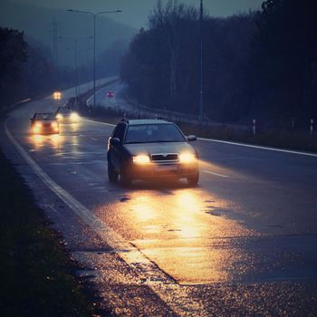 Car on the road in the fog. Autumn landscape - dangerous road traffic in winter season.