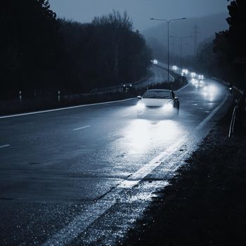 Car on the road in the fog. Autumn landscape - dangerous road traffic in winter season.