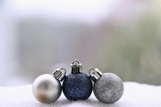 Christmas background. Beautiful decorations for the Christmas tree on real snow. Objects for the holidays and winter time.