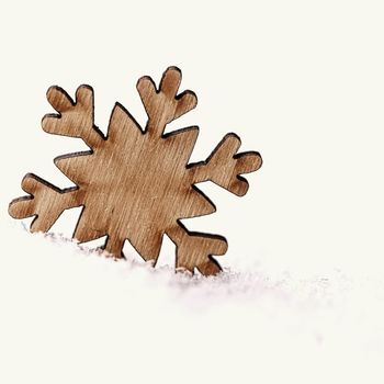 Christmas background. Christmas tree decoration - beautiful natural wooden snowflake with real snow. Background for winter and holiday. 