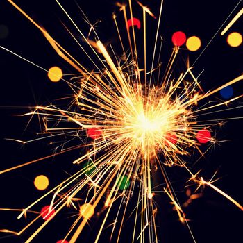 Sparkler with beautiful abstract colorful background. Concept for Christmas and Happy New Year 2021.