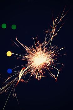 Sparkler with beautiful abstract colorful background. Concept for Christmas and Happy New Year 2021.