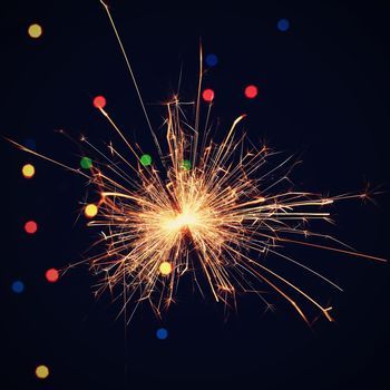 Sparkler with beautiful abstract colorful background. Concept for Christmas and Happy New Year 2021.