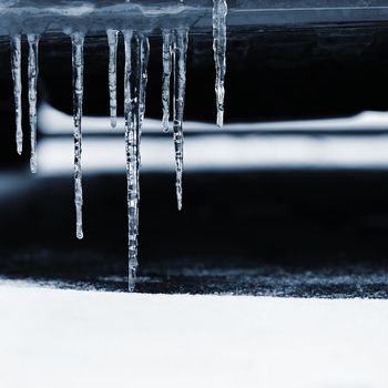 Beautiful icicles on the car. Concept for winter and dangerous winter traffic of cars on the road.