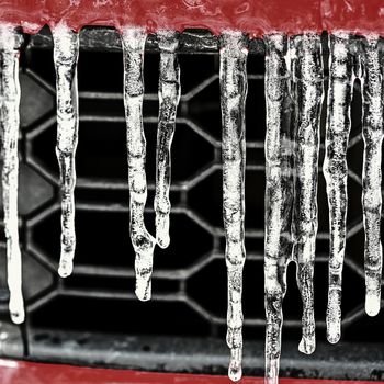 Beautiful icicles on the car. Concept for winter and dangerous winter traffic of cars on the road.